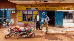 Two men stood outside a shop with a motorbike in front. Photo taken in Nairobi, Kenya