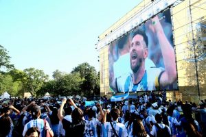 Lionel Messi on a big screen being watched by a crowd of Argentinian fans