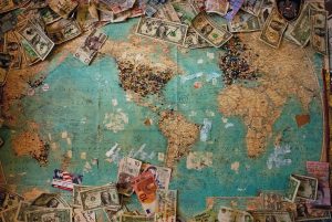 Money and pins on world map